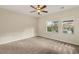 Bright, carpeted bedroom with large windows offering views of the landscaped backyard at 10179 Emerald Sunset Ct, Las Vegas, NV 89148