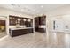 Open-concept kitchen boasts dark wood cabinetry, a large center island, and elegant pendant lighting at 10179 Emerald Sunset Ct, Las Vegas, NV 89148