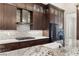 Modern kitchen featuring stainless steel appliances, granite counters, and dark wood cabinetry at 10179 Emerald Sunset Ct, Las Vegas, NV 89148