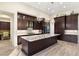Gourmet kitchen with dark wood cabinets, a large island, and stainless steel appliances at 10179 Emerald Sunset Ct, Las Vegas, NV 89148