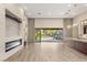 Spacious living room featuring modern fireplace, sleek tile flooring, and backyard access at 10179 Emerald Sunset Ct, Las Vegas, NV 89148