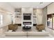 Staged living room features modern fireplace, shelving, recessed lighting, and sliding glass door to patio at 10179 Emerald Sunset Ct, Las Vegas, NV 89148
