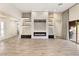 Bright open floor plan with built-in shelving, tile flooring, and fireplace at 10179 Emerald Sunset Ct, Las Vegas, NV 89148
