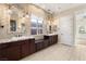 Luxury main bathroom featuring dual vanities, granite counters, and decorative mirrors at 10179 Emerald Sunset Ct, Las Vegas, NV 89148