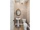 Charming powder room features wood-look floors, pedestal sink, and decorative mirror at 10179 Emerald Sunset Ct, Las Vegas, NV 89148
