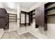 A walk-in closet with dark wood organizers, shelves, drawers and hanging rods for optimal storage at 10179 Emerald Sunset Ct, Las Vegas, NV 89148