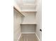 An organized walk-in closet featuring wooden rods and shelves with neutral carpeting at 10179 Emerald Sunset Ct, Las Vegas, NV 89148