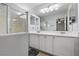 Well-lit bathroom with double sinks, white cabinets, and a separate shower at 10273 Grecian Laurel Ct, Las Vegas, NV 89183