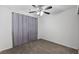 Neutral carpeted bedroom featuring a ceiling fan and window with privacy curtains at 10273 Grecian Laurel Ct, Las Vegas, NV 89183