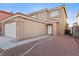 Beige stucco two-story home with a tile roof, attached garage, and low-maintenance desert landscaping at 10273 Grecian Laurel Ct, Las Vegas, NV 89183