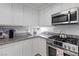 Spacious kitchen featuring stainless steel appliances, granite countertops, and sleek white cabinetry at 10273 Grecian Laurel Ct, Las Vegas, NV 89183