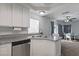 Bright kitchen features a stainless steel dishwasher, granite counters and a view into the dining and living area at 10273 Grecian Laurel Ct, Las Vegas, NV 89183