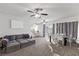 Bright living room with neutral walls, ceiling fan, carpet flooring, stylish furniture and view into kitchen and dining area at 10273 Grecian Laurel Ct, Las Vegas, NV 89183