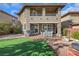 Spacious backyard with synthetic lawn, stone landscaping, and covered patio seating area at 10313 Aragon Crown Rd, Las Vegas, NV 89135
