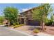 Charming two-story home boasting a paved driveway, stone accents, and lush landscaping at 10313 Aragon Crown Rd, Las Vegas, NV 89135