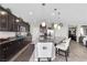 Modern kitchen boasts a large center island with seating, stainless steel appliances, and dark cabinetry at 10313 Aragon Crown Rd, Las Vegas, NV 89135