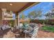 Inviting covered patio with a swing, glass-top table, and charming white cushioned seating at 10313 Aragon Crown Rd, Las Vegas, NV 89135