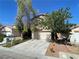 Charming two-story home featuring a well-maintained lawn, mature trees, and a two-car garage at 11147 Verismo St, Las Vegas, NV 89141