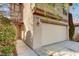 Close up of stucco home with a two-car garage, front door and low maintenance landscaping at 11147 Verismo St, Las Vegas, NV 89141