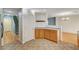 Kitchen area featuring wood cabinetry, tile floors, and easy access to the stairs and other parts of the home at 11147 Verismo St, Las Vegas, NV 89141