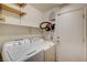 The laundry room features a washer, dryer, overhead shelves, and a door for easy backyard access at 11147 Verismo St, Las Vegas, NV 89141