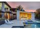 Luxurious backyard featuring a pool, spa, covered patio with modern seating, and beautiful landscaping at 1704 Tangiers Dr, Henderson, NV 89012