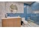 Modern bathroom featuring blue tile, geometric wallpaper, and a glass-enclosed shower at 1704 Tangiers Dr, Henderson, NV 89012