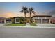 Charming home featuring desert landscaping, a wide driveway, and a three-car garage, beautifully lit at sunset at 1704 Tangiers Dr, Henderson, NV 89012