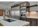 Modern kitchen featuring stainless steel appliances, marble countertops, and a view to the living area at 1704 Tangiers Dr, Henderson, NV 89012