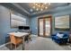 Modern office featuring blue walls, a tray ceiling, contemporary lighting, and glass doors leading to the outdoor area at 1704 Tangiers Dr, Henderson, NV 89012