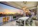Stylish outdoor dining area on balcony with modern furniture, decorative lighting, and beautiful sunset view at 1704 Tangiers Dr, Henderson, NV 89012