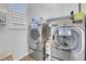 Well-lit laundry room equipped with front-loading washer and dryer with storage at 193 Calabria Peak Ct, Henderson, NV 89012