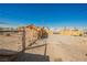 Large, empty, gravel backyard featuring an orange fence and partial views of buildings in the distance at 203 N 13Th St, Las Vegas, NV 89101