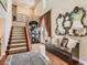 Inviting foyer with staircase, bench seat, decorative mirrors, and hardwood floors at 2038 Cherry Creek Cir, Las Vegas, NV 89135