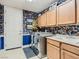 Well-lit laundry room with floral wallpaper, custom cabinets, sink, and modern appliances at 2038 Cherry Creek Cir, Las Vegas, NV 89135