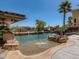Resort style pool features a sandy beach entrance, rocks and water features and lush landscaping at 2038 Cherry Creek Cir, Las Vegas, NV 89135