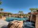 A custom pool with a stone waterfall feature and a covered outdoor kitchen in a private backyard oasis at 2038 Cherry Creek Cir, Las Vegas, NV 89135
