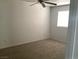 Neutral walls and neutral carpet feature in this bedroom with a ceiling fan and window at 2736 Stargate St, Las Vegas, NV 89108