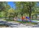 Community playground with colorful play structures, slides, and picnic areas surrounded by lush trees at 301 Treehouse Ct, Henderson, NV 89012