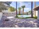 Beautiful backyard featuring a pool with a slide, a brick-paved patio, and mature palm trees, offering a tranquil escape at 3431 Iberia St, Las Vegas, NV 89146