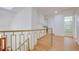 Bright hallway with wood floors, white walls, and a gold railing leading to the next floor at 3431 Iberia St, Las Vegas, NV 89146