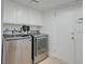 Laundry room with stainless steel washer and dryer set, cabinetry, and tile floors at 3431 Iberia St, Las Vegas, NV 89146