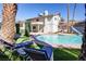 Backyard pool with lounge chairs, mature trees, and a slide, creating a relaxing and fun outdoor space at 3431 Iberia St, Las Vegas, NV 89146