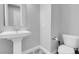 Compact powder room with a pedestal sink, toilet, and gray wood-look tile flooring at 351 Dandelion Brook Ct Ct, Las Vegas, NV 89148