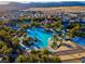 Aerial view of a large community pool surrounded by palm trees, recreational features, and residential homes at 351 Dandelion Brook Ct Ct, Las Vegas, NV 89148