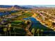 Picturesque aerial view of a golf course featuring lush greens, a scenic lake, and mature palm trees at 351 Dandelion Brook Ct Ct, Las Vegas, NV 89148