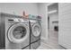 Laundry room featuring modern side-by-side washer and dryer with folding shelf above at 351 Dandelion Brook Ct Ct, Las Vegas, NV 89148