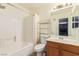 Bright bathroom featuring a tub with shower, white tile and a mirrored vanity at 3866 Starfield Ln, Las Vegas, NV 89147
