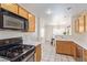 Well-lit kitchen featuring oak cabinetry, modern appliances, and an open view into the dining area, ideal for entertaining at 3866 Starfield Ln, Las Vegas, NV 89147