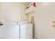 Neat laundry room features a modern washer and dryer with storage, and a door at 3866 Starfield Ln, Las Vegas, NV 89147